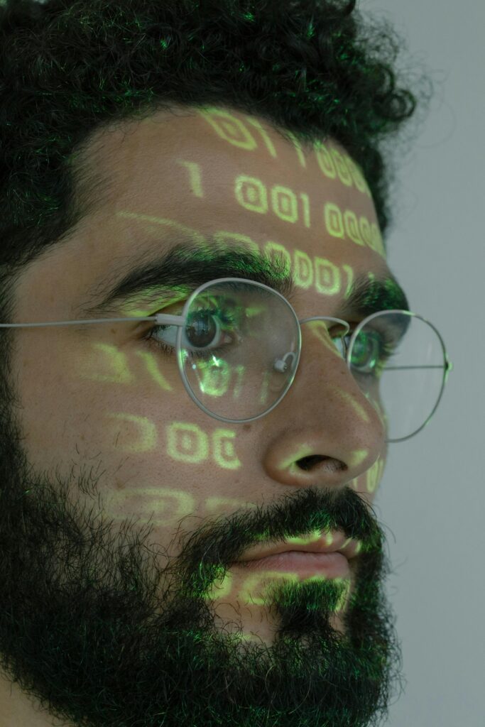 Close-up of a man with binary code projection reflecting digital identity.